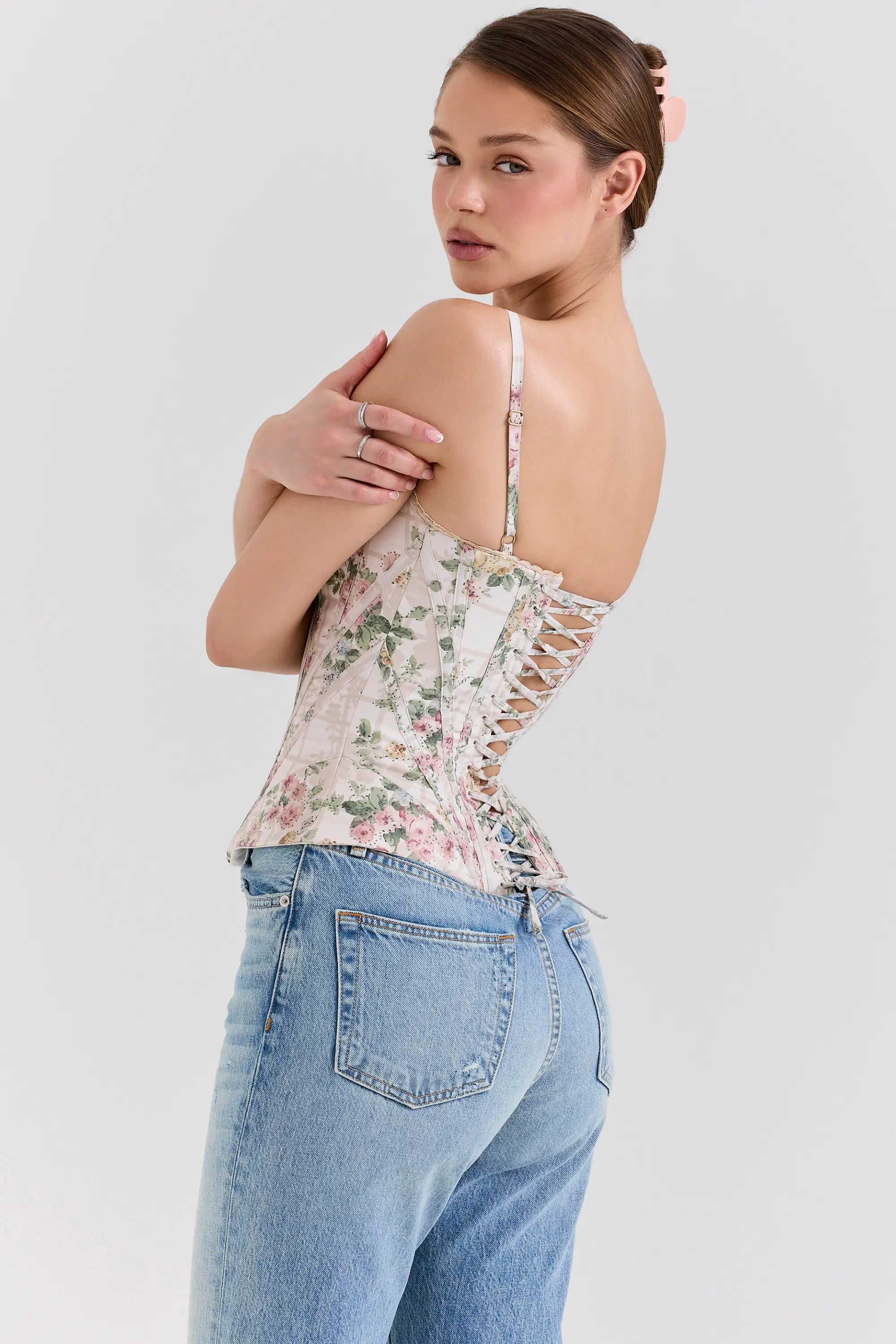 Modelo usando el Corset Selene Floral Vintage – estructura visible y estampado romántico sobre fondo crema