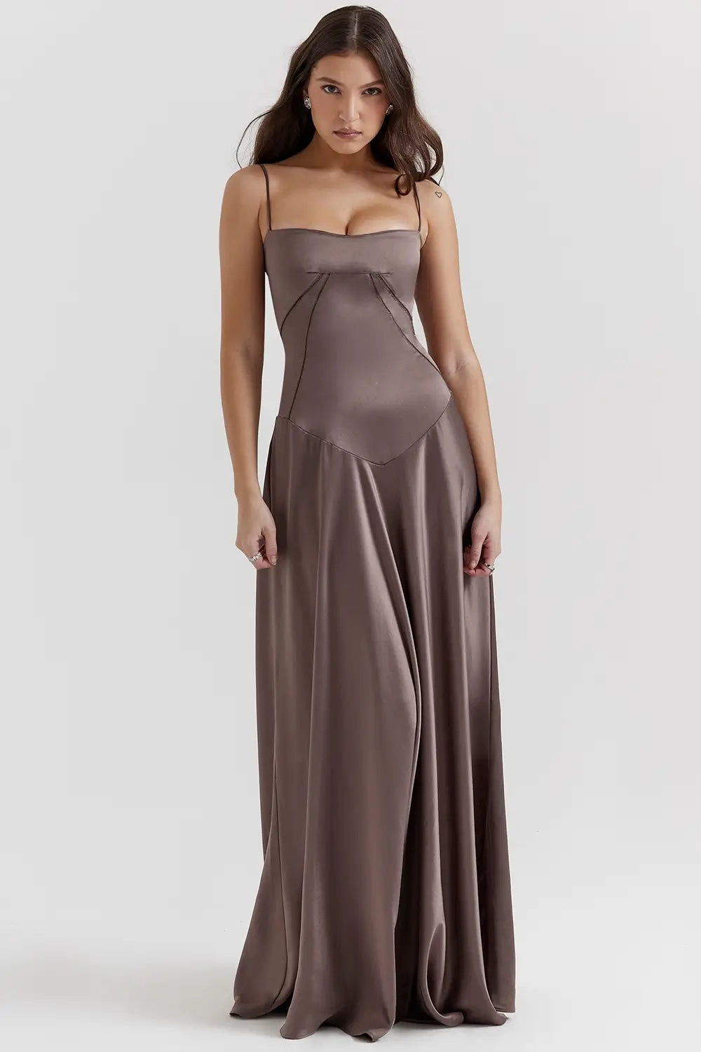 Vestido largo marron elegante para mujer con espalda descubierta y detalle de encaje delicado, ideal para bodas, fiestas formales, cenas especiales y eventos de noche. El modelo Mavie de Veliara está confeccionado en una tela de caída fluida que se adapta al cuerpo con suavidad, realzando la silueta sin apretar. Su escote recto y diseño sin tirantes ofrecen un look sofisticado y sensual, mientras que el encaje en la espalda añade un toque de romanticismo moderno.