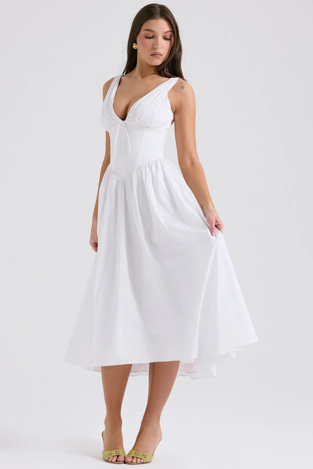 Modelo usando vestido blanco midi con escote profundo y corset – ideal para boda civil