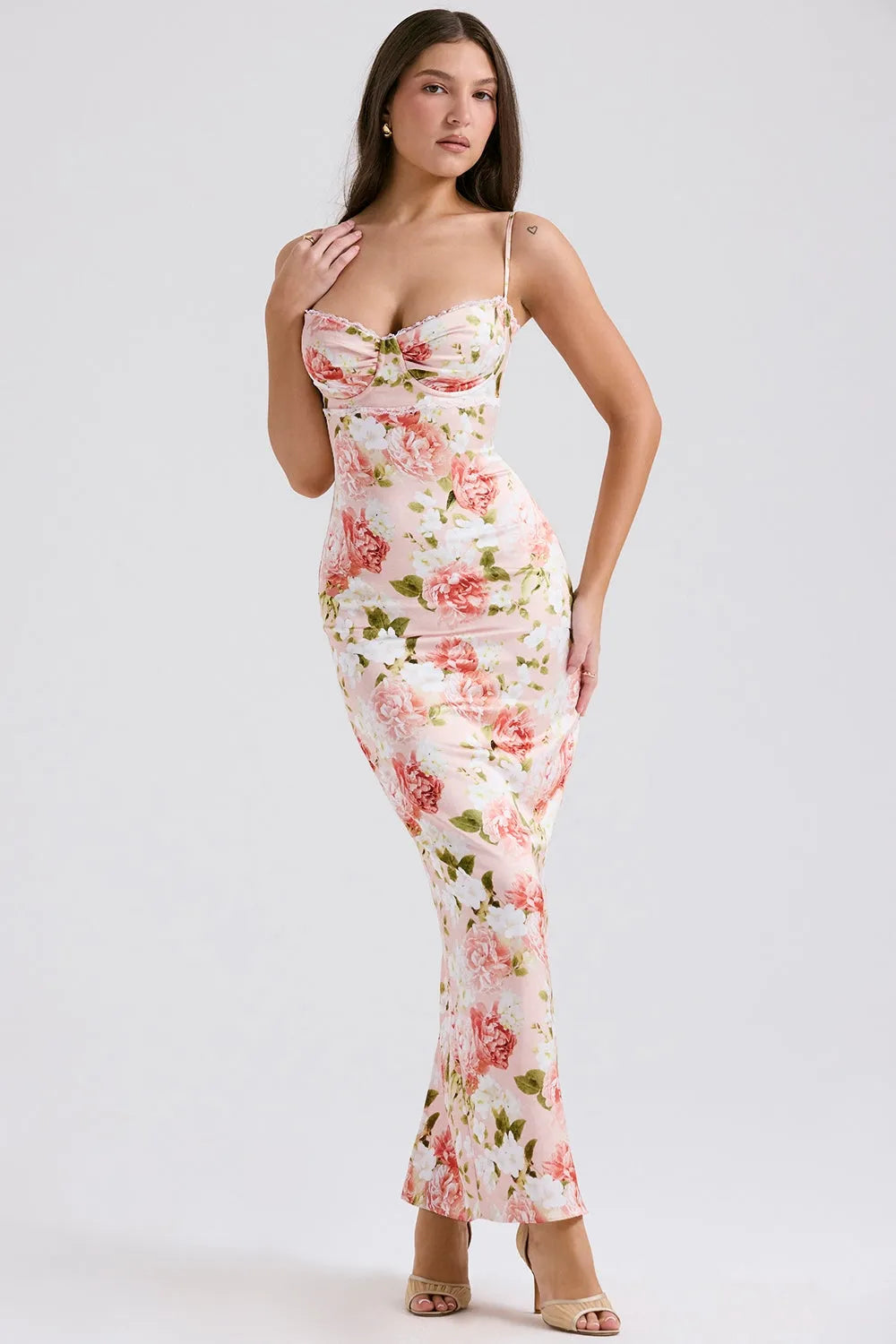 Modelo usando vestido largo floral ajustado al cuerpo con tirantes finos, ideal para fiestas y bodas.